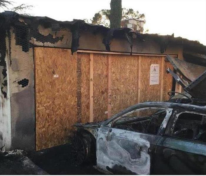 boarded up garage and burned car