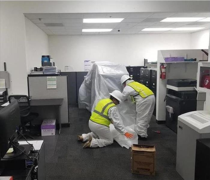 workers covering office furniture